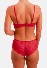 Rotes Spitzen-BH- und Slip-Set mit gewellten Kanten, verstellbaren Trägern und floralen Mustern. Rückansicht zeigt detaillierte Spitzenstruktur.
