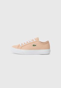 Lys rosa lær sneaker med hvite snører, teksturert overflate, hvit gummisåle og en grønn krokodillelogo på siden.