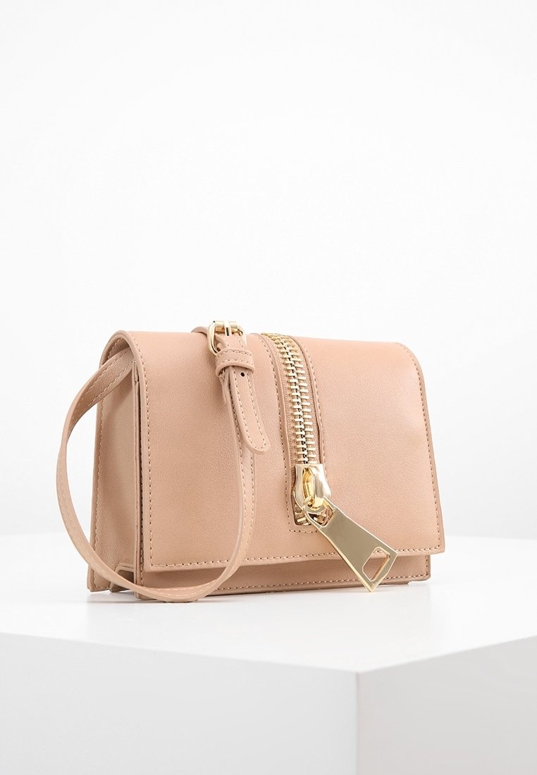 Brązowa torebka skórzana w prostokątnym kształcie, z długim złotym zamkiem błyskawicznym na przodzie oraz odczepianym paskiem dla większej wszechstronności.
