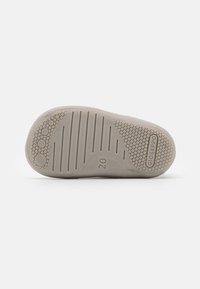 Suela de zapato de goma gris claro con agarre texturizado, patrones circulares y lineales, que presenta el nombre de la marca "Gioseppo" y el tamaño "20."