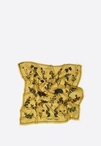 Żółty szalik wykonany z miękkiej tkaniny, zdobiony kwiatowym wzorem z ciemnymi akcentami oraz frędzlami na krawędziach. Wyświetlona nazwa marki "BIMBA Y LOLA".