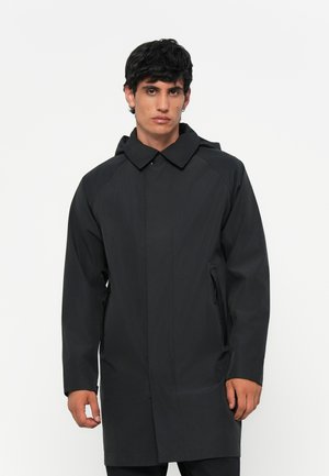 Black raincoat with a hood, made of smooth water-resistant fabric. Features a buttoned collar and side zippered pockets.