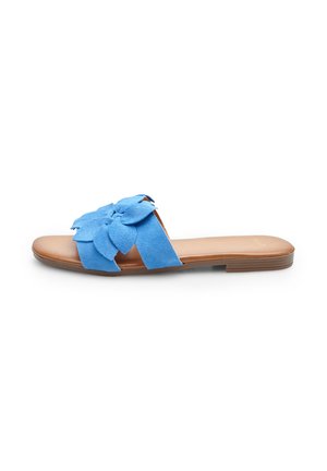 Suede blue slide sandal with a large flower design on the strap. Features a tan footbed and a flat, brown rubber sole.