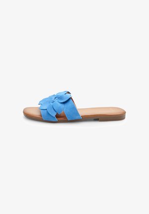Suede blue slide sandal with a large flower design on the strap. Features a tan footbed and a flat, brown rubber sole.