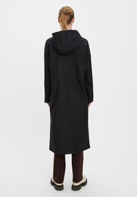 Black, long hooded coat with a straight cut, featuring a smooth texture and minimal stitching, shown from the back.