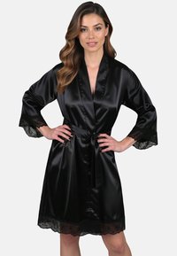 Schwarzer Satin-Roben mit Spitzenakzenten an den Ärmeln und am Saum, ausgestattet mit einem Bindegürtel und einem tiefen V-Ausschnitt. Glatte Textur, eleganter Abschluss.