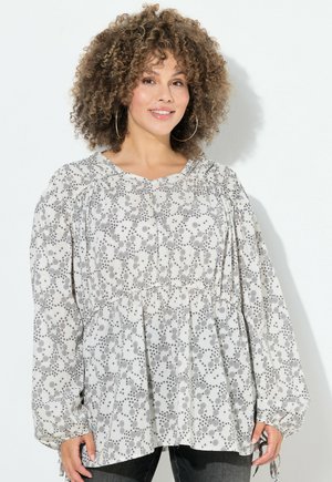 Biała bluzka z długim rękawem w czarny kwiatowy wzór, zebrane rękawy i zgromadzony w pasie. Miękka tkanina o luźnym kroju i okrągłym dekolcie.