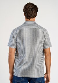 Koszula z krótkim rękawem w szaro-białe paski, z kołnierzykiem i luźnym krojem, wykonana z lekkiego materiału.