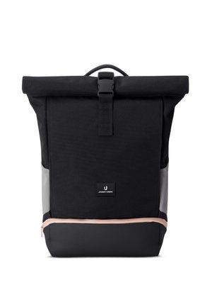 Schwarzer Rolltop-Rucksack mit Frontschnalle, grauen Seitenpaneelen, unterem Reißverschlussfach mit beigem Reißverschluss und kleinem rechteckigem Logopatch.