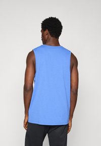 Blå bomulds tanktop med rund halsudskæring og uden ærmer; har en lige kant og en afslappet pasform.
