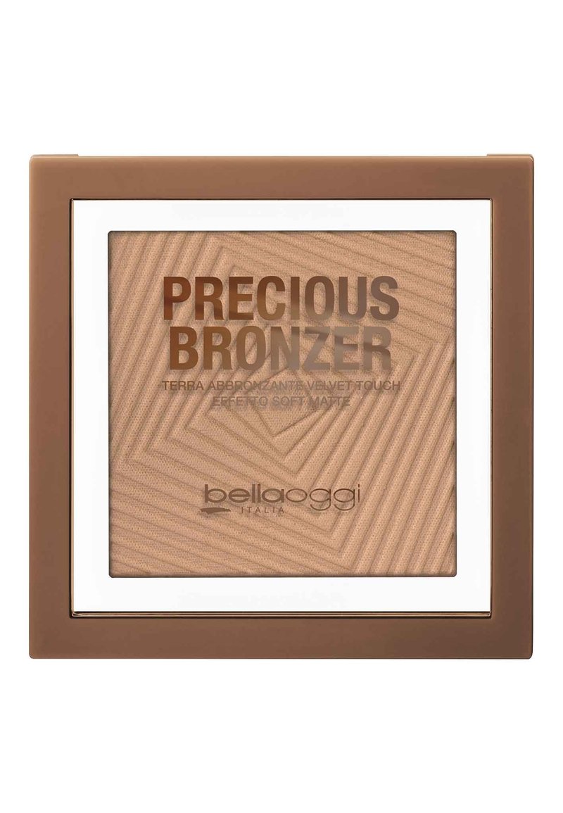 Compact di bronzer con texture geometrica in marrone chiaro. Presenta una finestra trasparente e un bordo bianco, con nome del marchio e dettagli del prodotto in rilievo.
