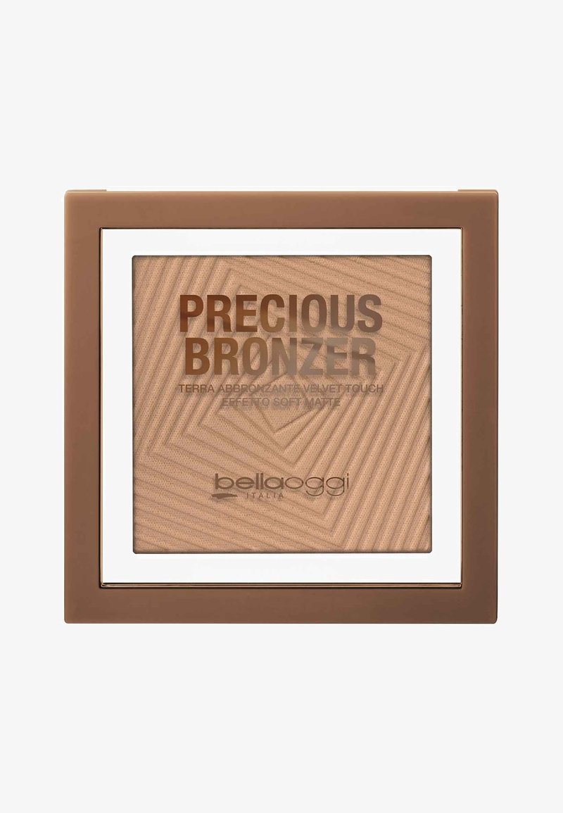 Compact di bronzer con texture geometrica in marrone chiaro. Presenta una finestra trasparente e un bordo bianco, con nome del marchio e dettagli del prodotto in rilievo.
