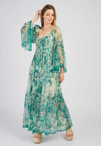 Robe maxi en tissu transparent, ornée de motifs floraux bleu-vert, avec un corsage ajusté, des manches évasées et un ourlet en couches. Texturée avec un léger éclat.