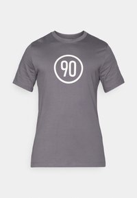 Maglietta grigia in cotone, con una grafica rotonda bianca al centro che riporta il numero "90". Design con maniche corte e scollo rotondo.