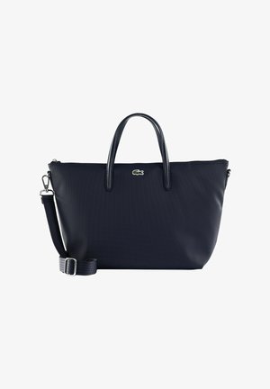 Sac fourre-tout noir Lacoste avec double poignée, bandoulière détachable et ajustable, et logo crocodile vert au centre avant.