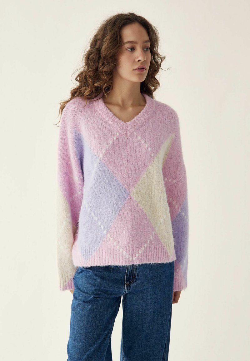 Pullover in Pastellpink, Lavendel und Creme mit einem Rautenmuster. Aus weichem Stoff gefertigt, mit V-Ausschnitt und geripptem Saum.