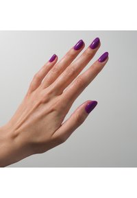 Une main avec des doigts allongés, arborant un vernis à ongles violet brillant sur des ongles en forme d'amande, sur un fond gris clair.