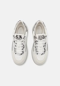 Sneakers bianchi con dettagli in pelle di pitone nera e bianca a trama, con lacci rotondi, tacco imbottito e suola in gomma grigia.
