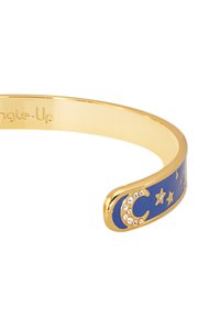 Bracelet en or avec une surface en émail bleu, ornée d'un design en forme de croissant de lune et d'étoiles rehaussé de strass transparents.