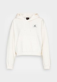 Ljusbeige kort hoodie med dragskohuva, framficka av kangaroo-typ och elastiska muddarna. Har en svart logotyp om patch på bröstet.