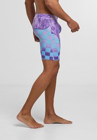 Lilla og turkise rutete boxertruser med en merket midje. Laget av elastisk stoff; glatt tekstur med en kroppsnær passform.