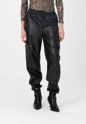 Zwarte neplederen cargobroek met een elastische tailleband, voorzien van zijzakken en boorden, gecombineerd met zwarte enkellaarzen.