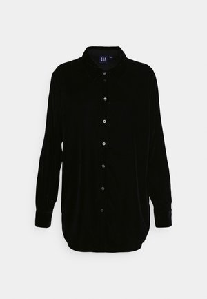 Chemise en velours noir à manches longues avec un devant boutonné, un col pointu et des manches à poignet ; texture lisse et coupe décontractée.