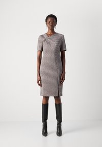 Robe à manches courtes avec un motif, à la silhouette ajustée, présentant un design en diagonale, des couleurs atténuées et une longueur au genou.