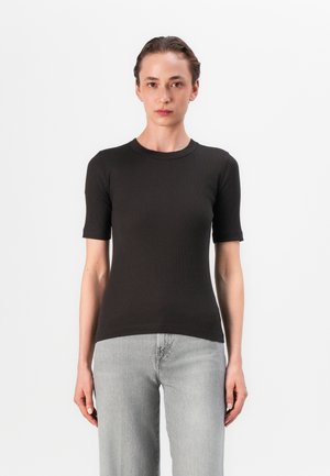 Black ribbed short-sleeve t-shirt with a round neckline. Soft texture, fitted design, paired with light gray straight-leg jeans.