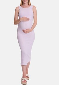 Lichtpaarse ribgebreide zwangerschapsjurk met een getailleerd silhouet, een knielengte zoom en een ronde halslijn, gecombineerd met beige platform sandalen.