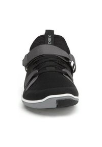 Svart och grå atletisk sko med nätövre, spännband, snörning och sula med vit kant, sedd framifrån.