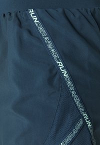 Granatowe sportowe szorty z teksturowanym bocznym panelem oraz taśmą z logo "UNDER ARMOUR" w jasnoniebieskim kolorze, z elastycznym paskiem dla komfortu.