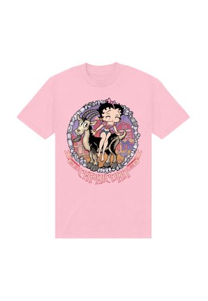 Lyserød t-shirt med et cartoon-design af en pige, der sidder på en sort ged, omkranset af en cirkulær ramme og teksten "Stenbukken".
