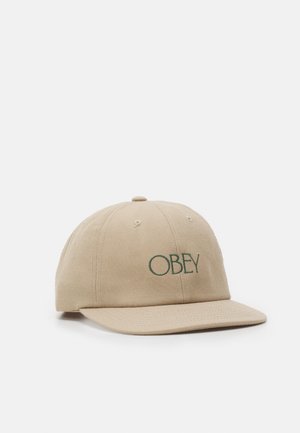 Boné bege feito de lona de algodão, com o logótipo verde "OBEY" bordado na frente. Aba curvada e design de seis painéis com buracos de ventilação.