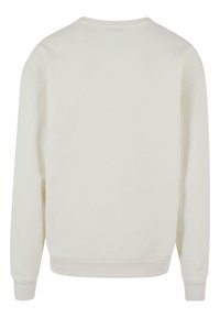 Felpa crema con scollatura rotonda, polsini e orlo a costine, e una texture liscia. La vista posteriore mostra un design semplice e minimalista.
