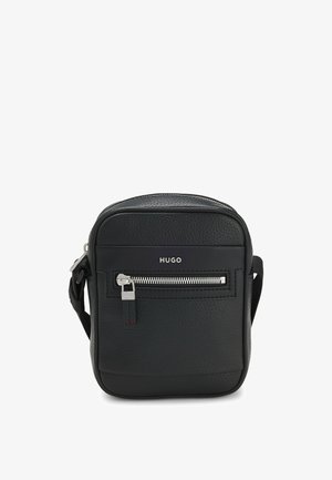 Zwart gestructureerde leren crossbodytas met voorvak met rits, zilveren rits en "HUGO"-logo boven het vak.
