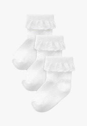 Calzini per bambini in cotone bianco con bordo di pizzo arricciato nella parte superiore e design testurizzato in tutto il corpo. Set di tre paia.
