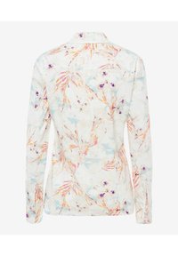 Chemise blanche à manches longues avec un motif floral pastel comprenant des accents orange, rose, violet et bleu, montrée de dos.