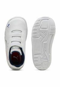 Chaussures de sport blanches avec fermeture à lacets élastiques, tige synthétique texturée, accents bleus et rouges, et semelle en caoutchouc à motifs pour une meilleure traction.
