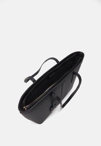 Sort struktureret tote bag med lange skulderremme og et centralt lynlåslomme, vist fra en topvinkel på en hvid baggrund.