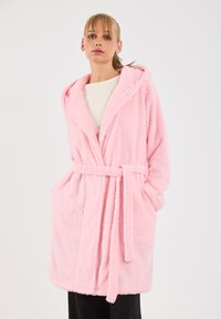 Rosa, flauschiger Bademantel mit Kapuze und Taillenkordel. Verfügt über einen strukturierten Stoff und zwei Seitentaschen. Knielang mit lockerer Passform.