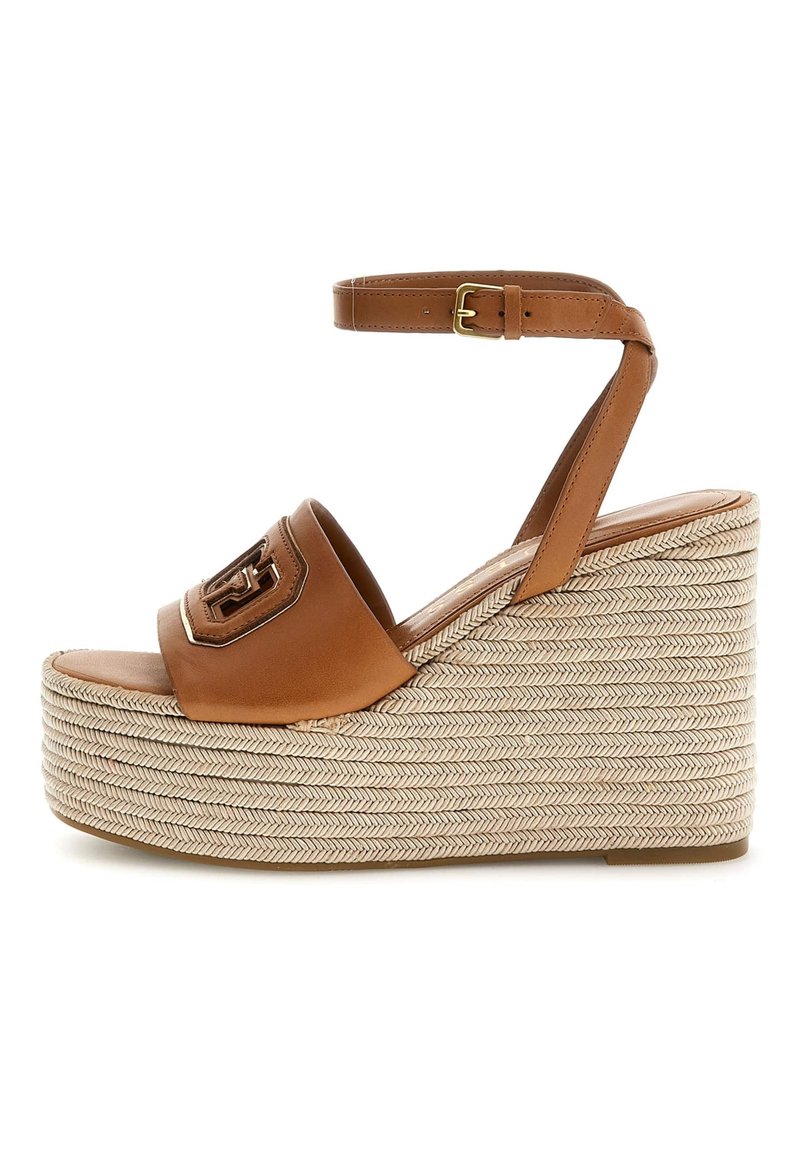 Hnědé kožené wedges sandály s tkanou jutovou platformou, páskem na kotníku, zlatým emblémem a hladkým matným povrchem.