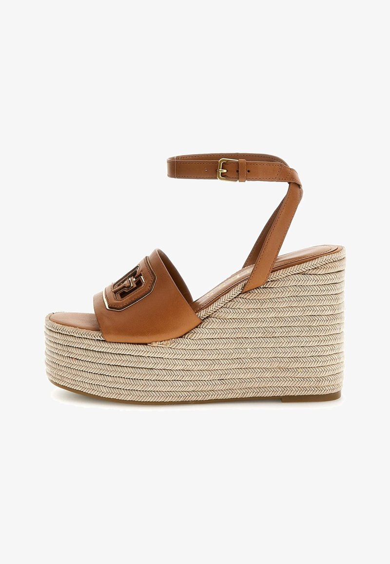 Hnědé kožené wedges sandály s tkanou jutovou platformou, páskem na kotníku, zlatým emblémem a hladkým matným povrchem.