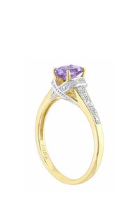 Zlatý prsteň s centrálne umiestneným levanduľovým drahokamom, ozdobený bielymi kameňmi na skrútenom striebornom pásiku, s hladkým lešteným povrchom.