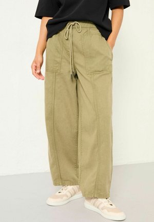 Olivegrüne weit geschnittene Cargo-Hose aus Baumwollstoff mit zwei Fronttaschen, verstellbarem Kordelzugbund und sichtbaren Nähten.