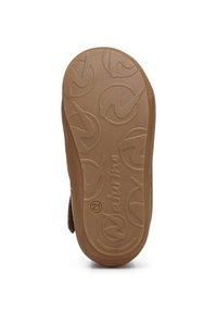 Suela de zapato de goma marrón con superficie texturizada que presenta patrones circulares y un detalle del logo. Punta ligeramente redondeada y bordes elevados.