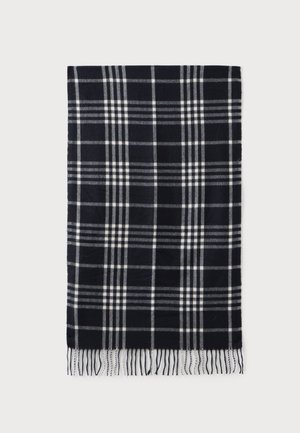 Black and white plaid scarf with fringed edges, laid flat on a plain light background.
