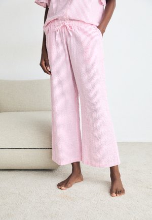 Lila och vit randig loungeklädset med en avslappnad passform. Tyget är texturerat och har en elastisk midja samt vida byxor.