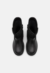 Schwarze Knöchelstiefel mit einer glatten Lederzehe und einem strukturierten Wildlederoberteil. Sie verfügen über zwei seitliche Reißverschlüsse und eine robuste Sohle für besseren Halt.