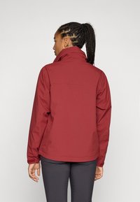 Red waterproof jacket with a high collar, elastic cuffs, and a smooth matte finish. Features a back yoke and subtle stitching details.